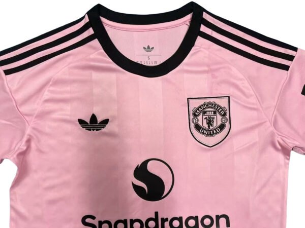 Pink Manchester United third soccer jersey with black accents, Adidas logo, and team crest.