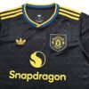 Manchester United 25/26 Soccer Jersey Manchester United 25/26 training soccer jersey with Adidas and Snapdragon logos.