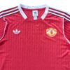 Manchester United third jersey 2025/26, red with white accents and club crest.