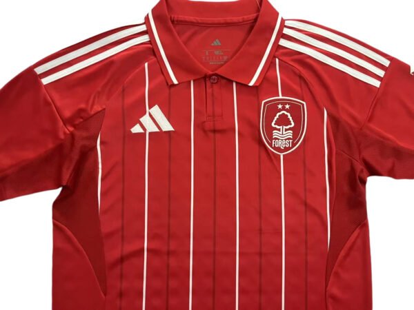 Manchester United third soccer jersey for 2025/26 season, red with white stripes.