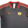 Manchester United third jersey 2025/26 with black and red design, Adidas logo, and team crest.