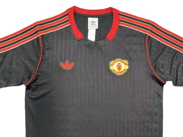 Manchester United third jersey 2025/26 with black and red design, Adidas logo, and team crest.