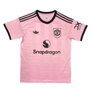 Pink Manchester United third soccer jersey with black accents and sponsor logo.