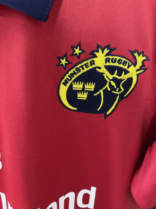 Hunting Rugby logo embroidered on red sports jersey, showcasing team branding and emblem.