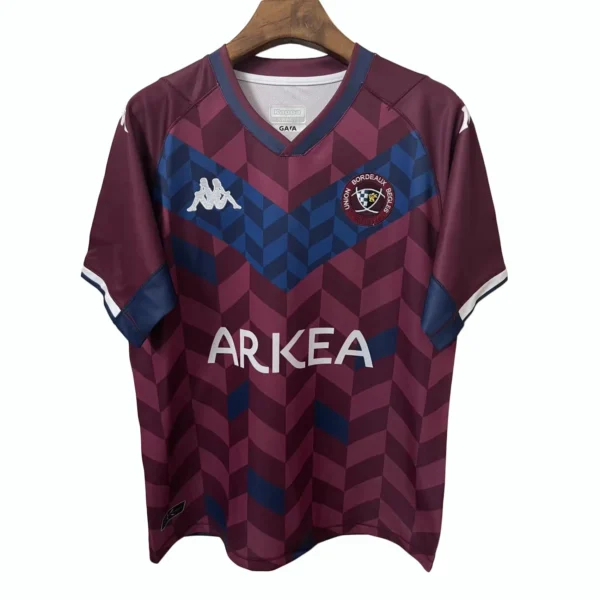 Soccer Jersey with Bordeaux and Blue Design Bordeaux and blue patterned soccer jersey with team logo and sponsor ARKEA.