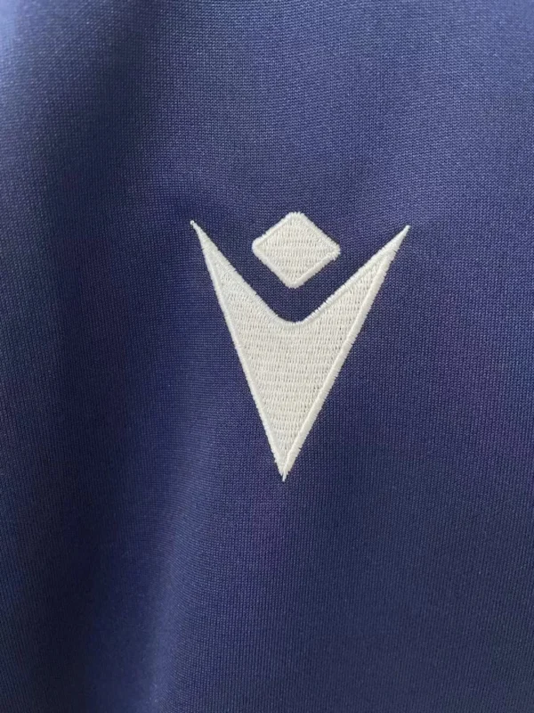 Sportswear logo on navy blue fabric, emphasizing athletic apparel branding. Close-up of a sportswear logo on navy blue fabric, highlighting quality athletic clothing branding.