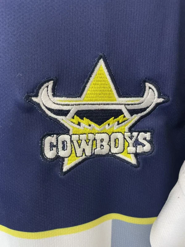 Dallas Cowboys sports team logo embroidered on navy blue fabric. Embroidered Dallas Cowboys logo featuring a star, horns, and team name on sports apparel.