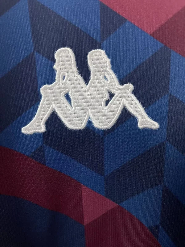 Sportswear embroidered logo patch on fabric background Embroidered logo patch featuring two stylized figures on sportswear fabric, ideal for athletic appar.
