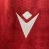 Sports jersey with logo and red patterned fabric background. Sports jersey logo, athletic wear, sports apparel, performance clothing, activewear, sports kit.