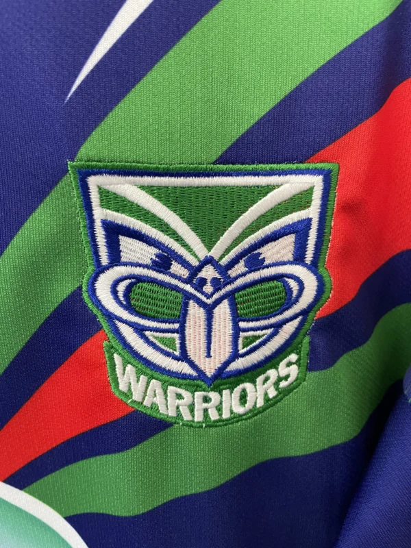 Warriors sports team emblem with vibrant green, blue, and red colors.