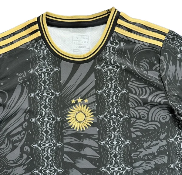 Sports jersey with intricate black and gray patterns and a prominent yellow sun emblem. Features classic Adidas three-stripe design on shoulders. 2026 Argentina Goat Special Edition Jersey