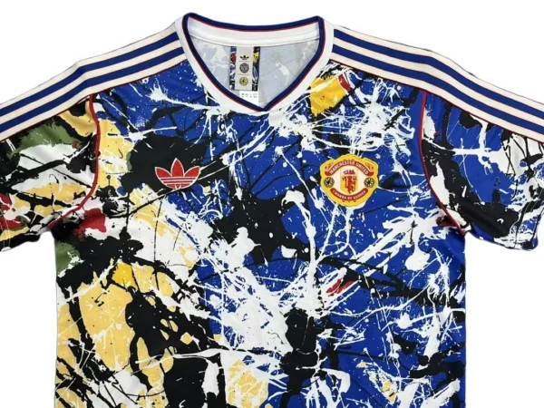 Colorful abstract sports jersey with Manchester United logo and Adidas stripes.