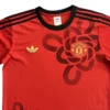 Manchester United Red Soccer Jersey with Floral Design Red Manchester United football jersey featuring floral pattern and black accents, ideal for sports a.