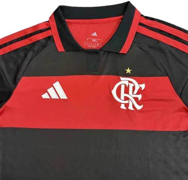 Football jersey with Flamengo logo and Adidas branding, black and red design. Flamengo football jersey with Adidas logo and team crest, ideal for sports fans.