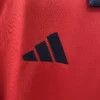 Close-up of Adidas logo on red athletic sportswear fabric.