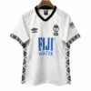 Football jersey with Fiji Water sponsorship, UK flag patch, and Polynesian-inspired black and white.
