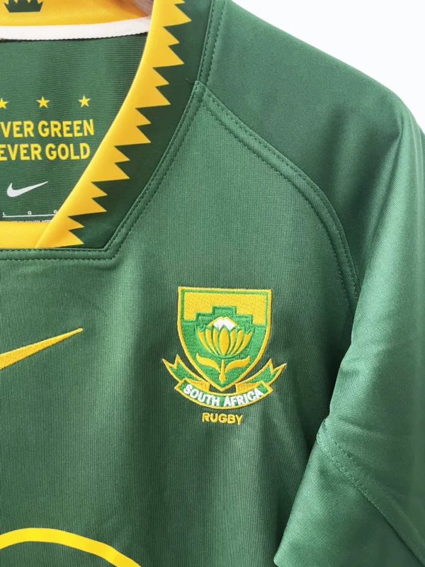 South Africa Rugby Jersey Close-up of South Africa rugby jersey with team emblem and vibrant green color.