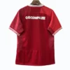 Football jersey with "COCOMPARE" logo on the back, red color, and white accents. Red football jersey with "COCOMPARE" logo on the back, designed for sports and team uniforms.