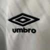 Umbro logo embroidered on white sports jersey fabric, showcasing athletic apparel branding.